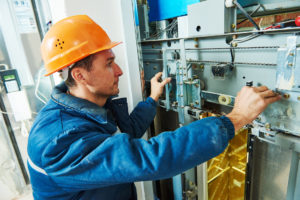 elevator technician worker adjusting elevator mechanism of lift